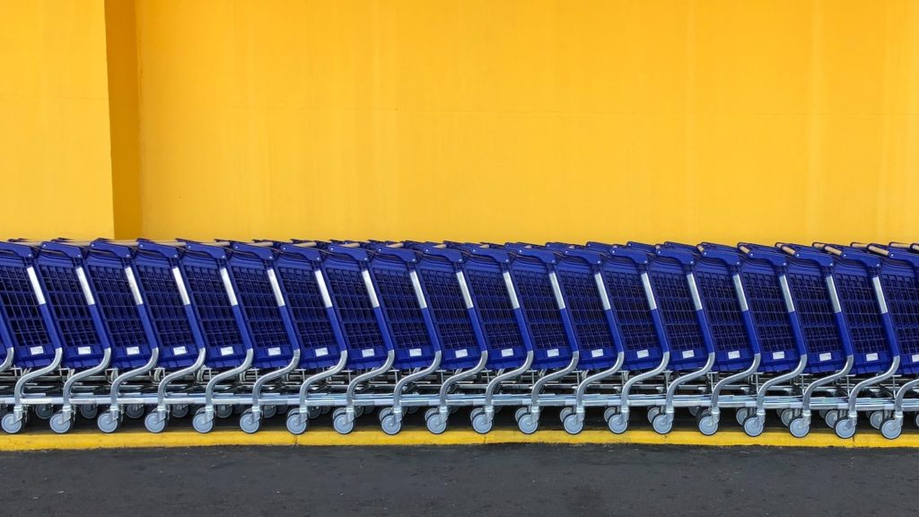 line of blue shopping carts against an orange background