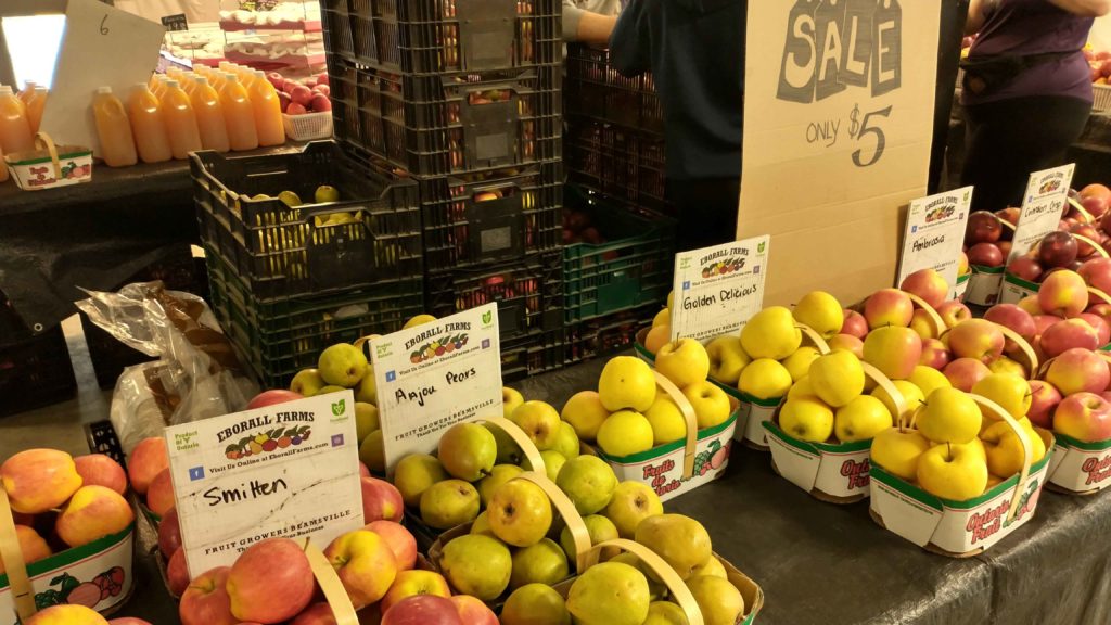 apples and pears being sold at a farmers market